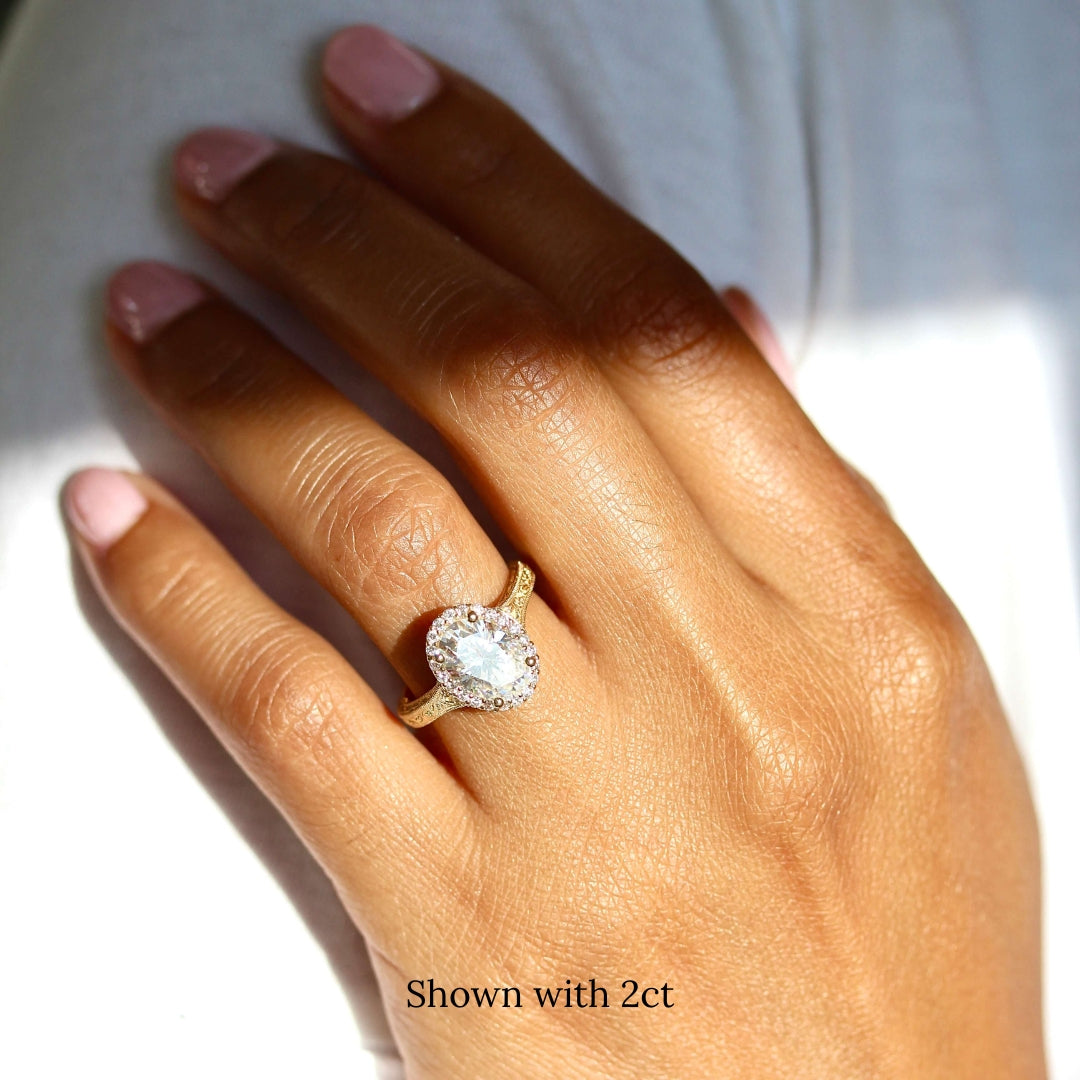 a 2ct oval engagement ring on a finger