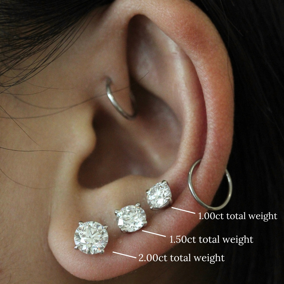 Three Classic Stud Earrings in white gold modeled on an ear