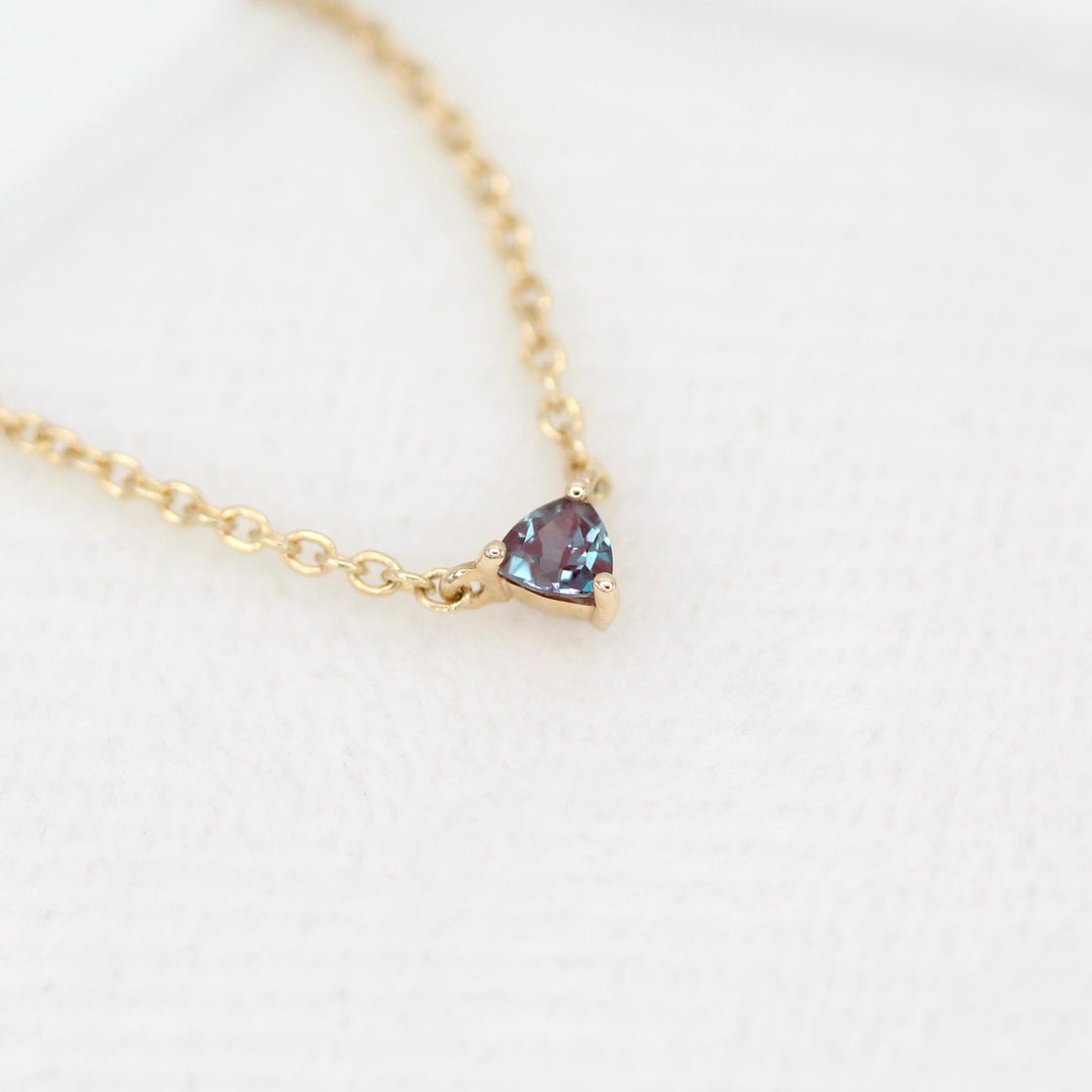 The June Birthstone Tiny Trillion Necklace with Alexandrite in Yellow Gold against a white background