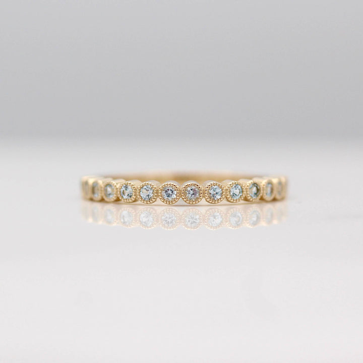 The Florence Wedding Band with Aqua Spinel in Yellow Gold against a white background