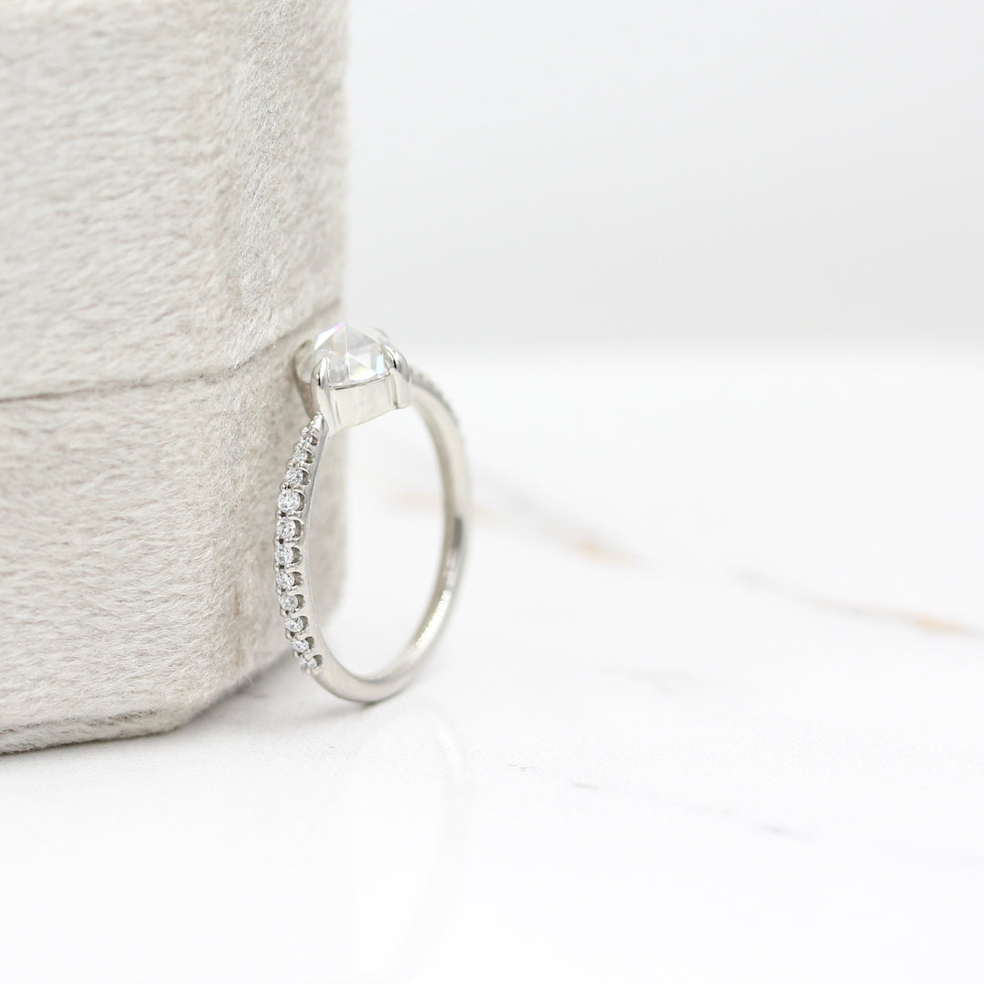 The Aurora Ring (Round) in Platinum leaning against a gray ring box
