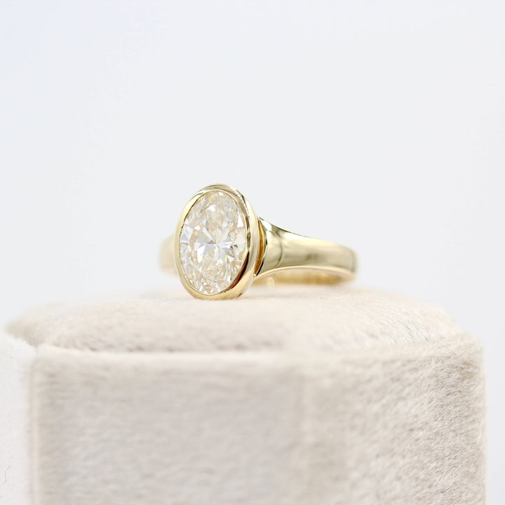 The Billie Ring (Oval) in Yellow Gold with 2ct Lab-Grown Diamond atop a white velvet ring box