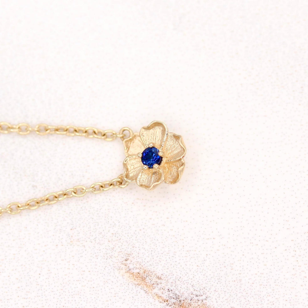 The September Birthstone Poppy Necklace with Blue Sapphire in Yellow Gold against a white background