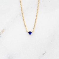 The September Birthstone Tiny Trillion Necklace with Blue Sapphire in Yellow Gold against a white background