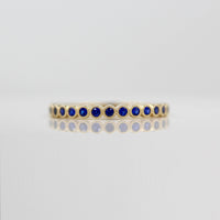 The Florence Wedding Band with Blue Sapphire against a white background