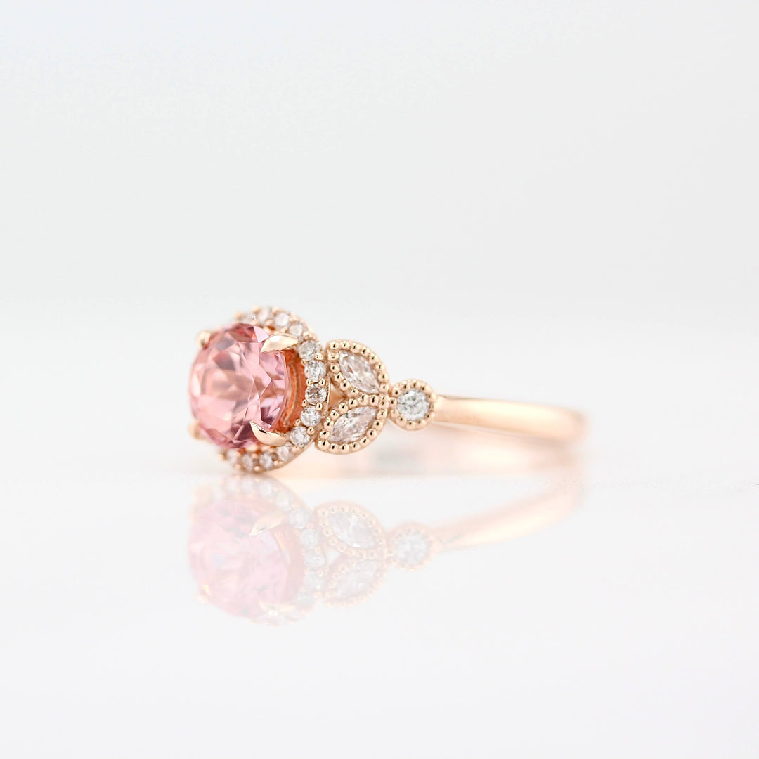 The Cate Ring (Round) in Rose Gold with 1ct Peachy-Pink Created Sapphire against a white background