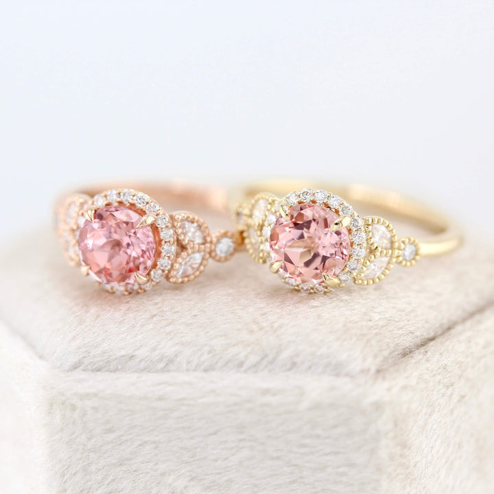 The Cate Ring (Round) in Rose Gold with 1ct Peachy-Pink Created Sapphire and the Cate Ring (Round) in Yellow Gold with 1ct Peachy-Pink Created Sapphire atop a white velvet ring box