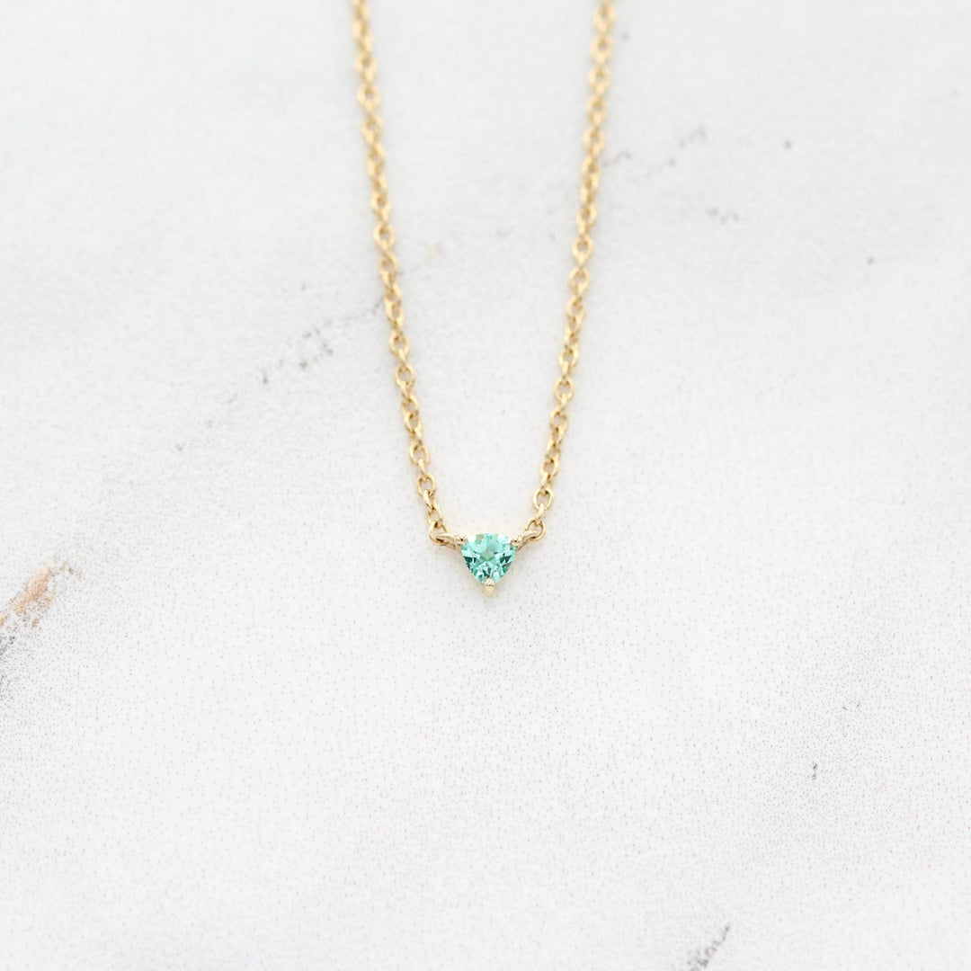 The August Birthstone Tiny Trillion Necklace with Chrysoberyl in Yellow Gold against a white background