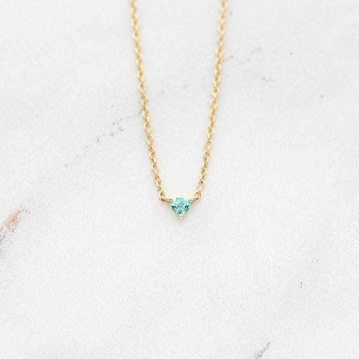 The August Birthstone Tiny Trillion Necklace with Chrysoberyl in Yellow Gold against a white background