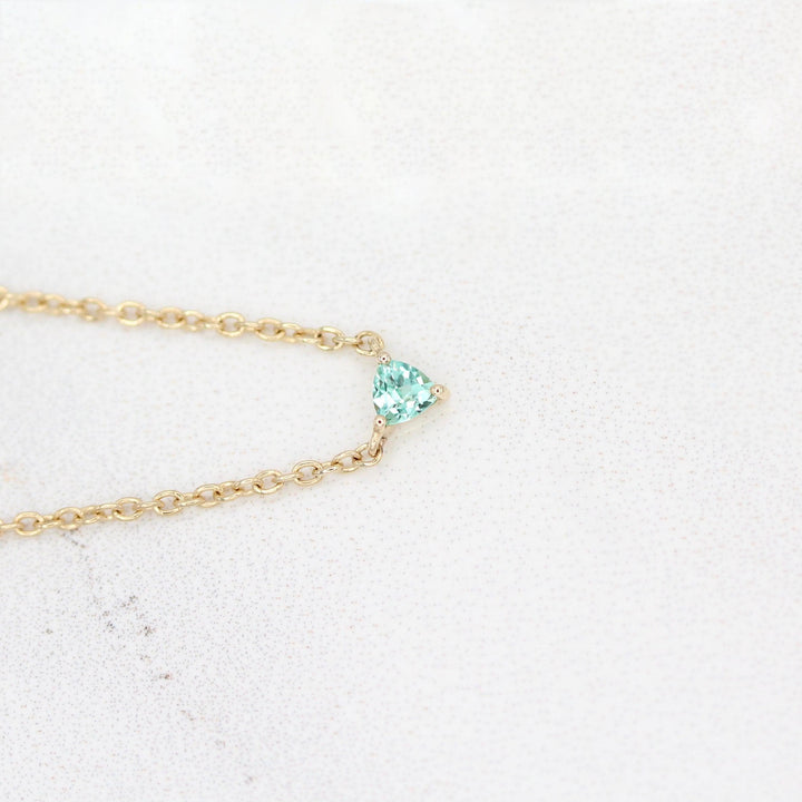 The August Birthstone Tiny Trillion Necklace with Chrysoberyl in Yellow Gold against a white background