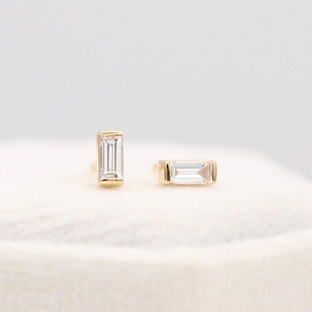 The April Baguette Birthstone Earrings with Lab-Grown Diamond in Yellow Gold atop of a white velvet ring box