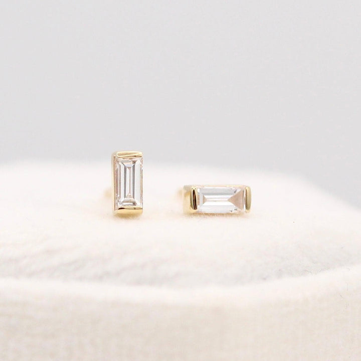 The April Baguette Birthstone Earrings with Lab-Grown Diamond in Yellow Gold atop of a white velvet ring box