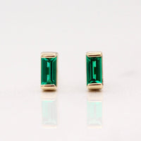 The May Baguette Birthstone Earrings with Emerald in Yellow Gold against a white background