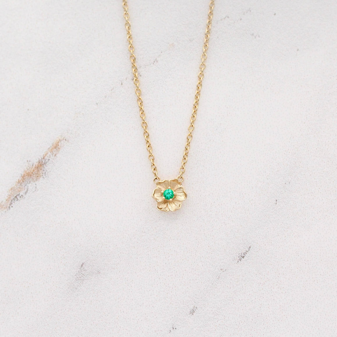 The May Birthstone Poppy Necklace with Emerald in Yellow Gold against a white background