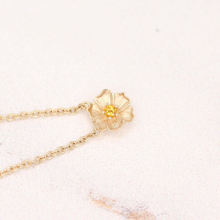 The November Birthstone Poppy Necklace with Gold Sapphire in Yellow Gold against a white background