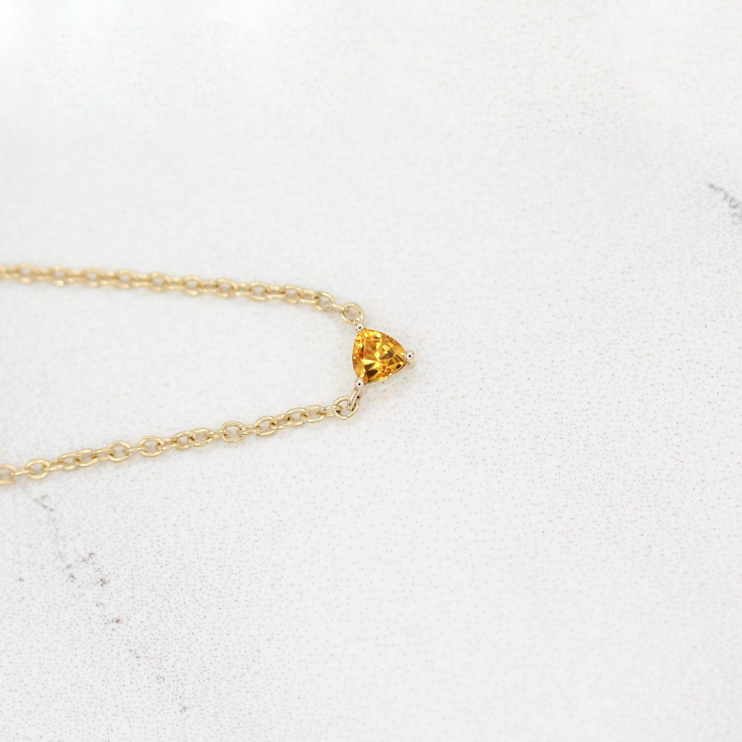 The November Birthstone Tiny Trillion Necklace with Gold Sapphire in Yellow Gold against a white background