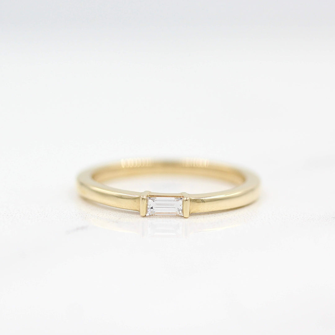 The Single Baguette Ring in Yellow Gold against a white background