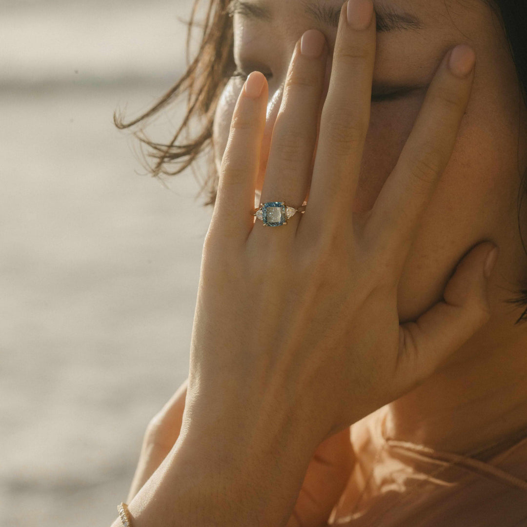 The Izzy Ring (Cushion) with 3.12ct Blue Lab-Grown Diamond in Yellow Gold modeled on a hand