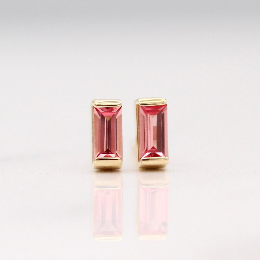 The January Birthstone Baguette Earrings with Padparadscha Sapphire in Yellow Gold against a white background