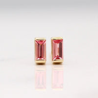 The January Birthstone Baguette Earrings with Padparadscha Sapphire in Yellow Gold against a white background