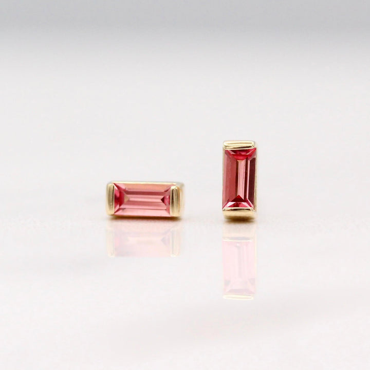 The January Birthstone Baguette Earrings with Padparadscha Sapphire in Yellow Gold against a white background