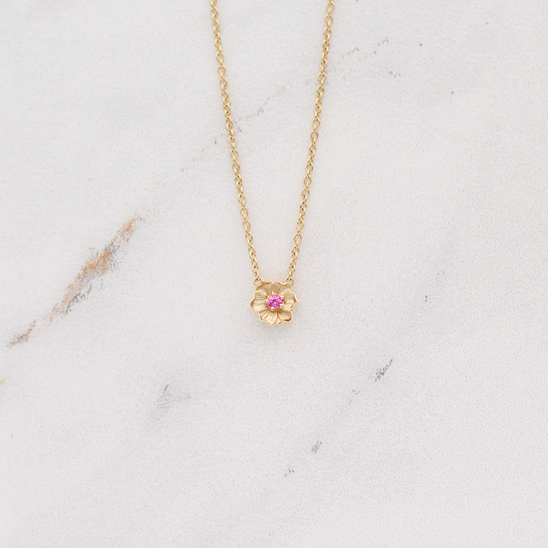 The January Birthstone Poppy Necklace with Padparadcha Sapphire in Yellow Gold against a white background