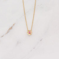 The January Birthstone Poppy Necklace with Padparadcha Sapphire in Yellow Gold against a white background