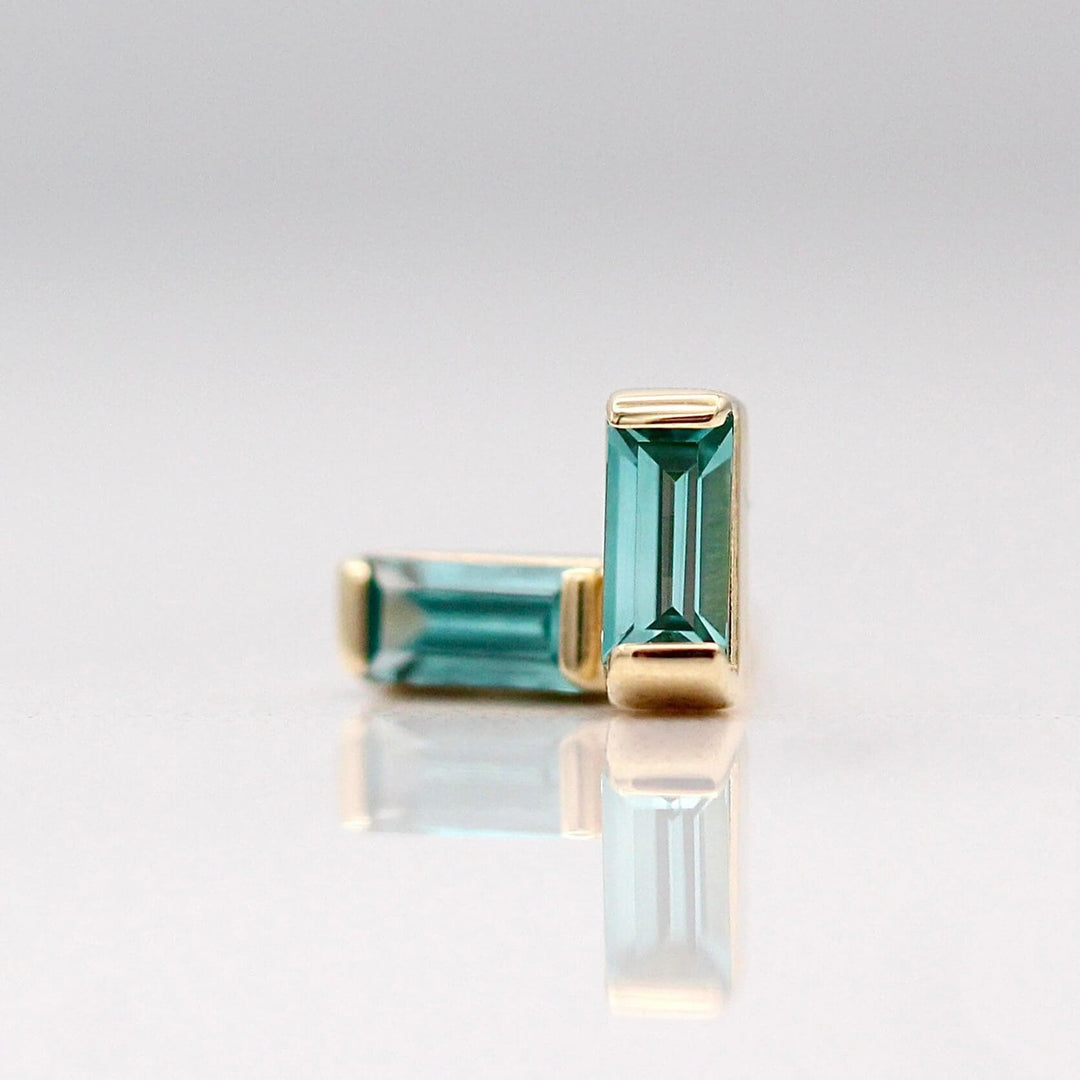 The December Birthstone Baguette Earrings with Paraiba Spinel in Yellow Gold  against a white background