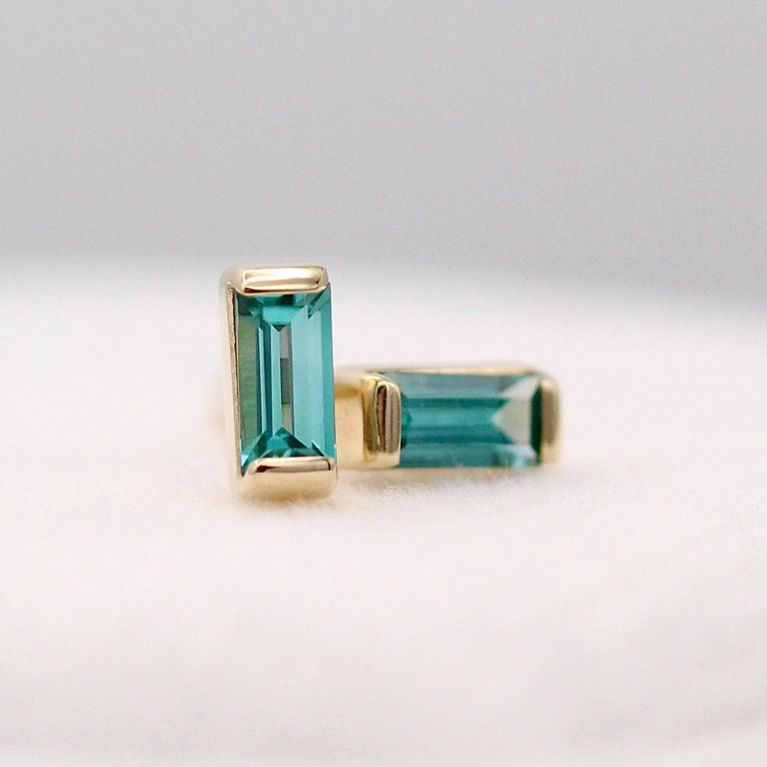 The December Birthstone Baguette Earrings with Paraiba Spinel in Yellow Gold  against a white background