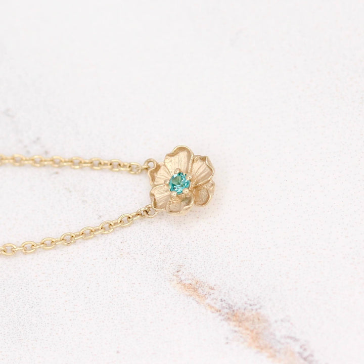 The December Birthstone Poppy Necklace with Paraiba Spinel in Yellow Gold against a white background