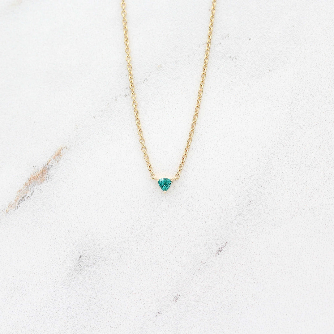 The December Birthstone Tiny Trillion Necklace with Paraiba Spinel in Yellow Gold against a white background