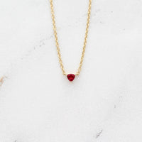 The July Birthstone Tiny Trillion Necklace with Ruby in Yellow Gold against a white background