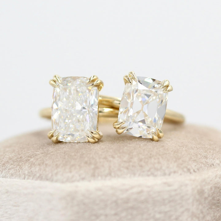 The Serena Ring (Antique Cushion) in Yellow Gold with 3.02ct Lab-Grown Diamond atop a white velvet ring box beside the Serena Ring (Elongated Cushion) in Yellow Gold with a 3.51ct Lab-Grown Diamond