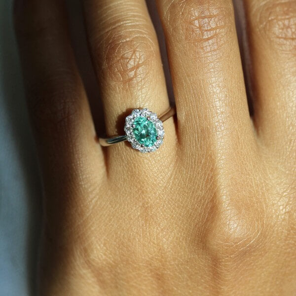 hand wearing minty green chrysoberyl diamond halo ring