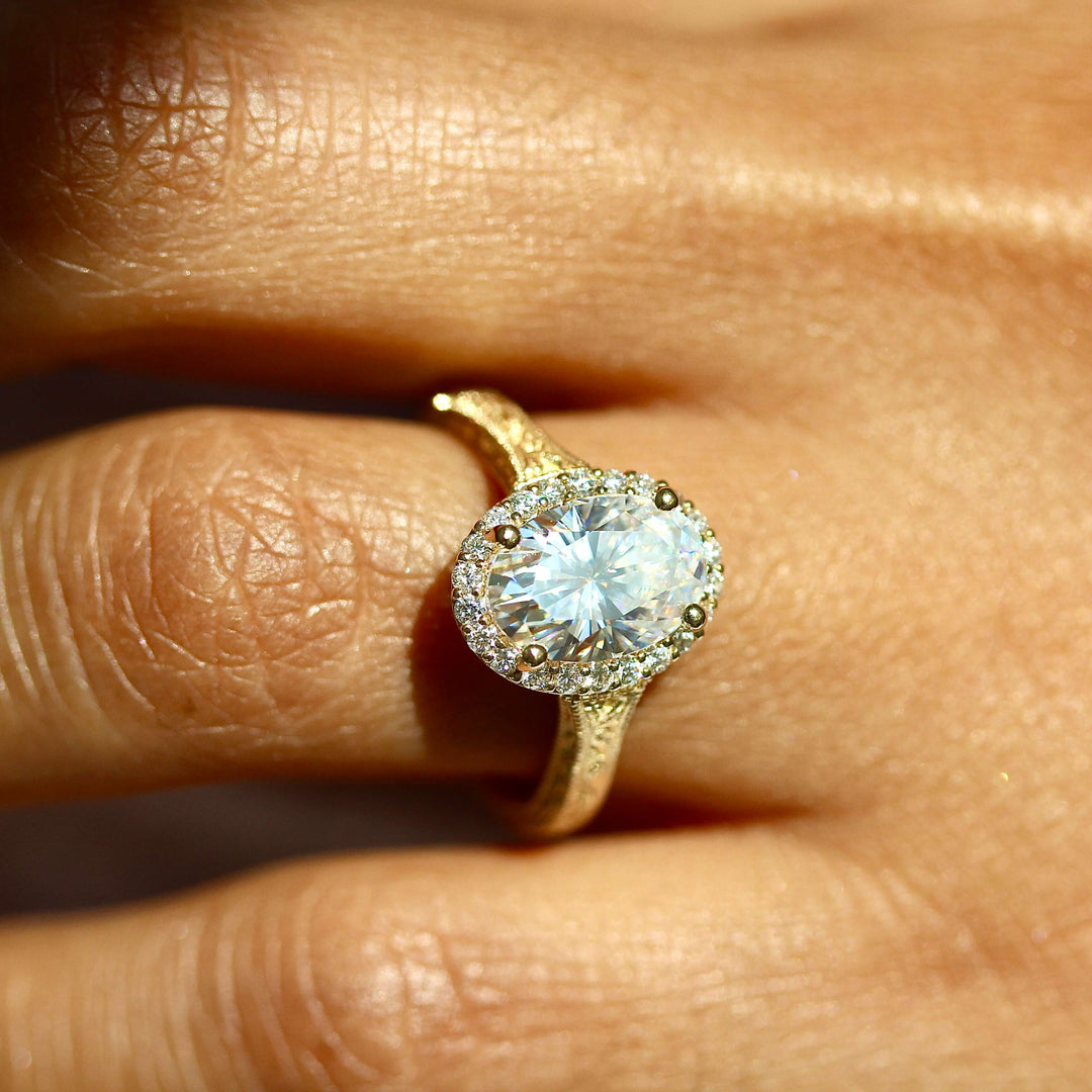 an oval engagement ring on a finger